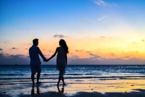 couple walking on beach representing retirement and how KPERS does help that