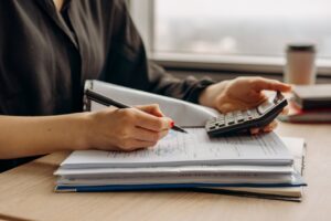 image of person holding calculator and writing